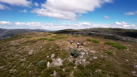 mountain bikers riding along a trail on top of a mountain