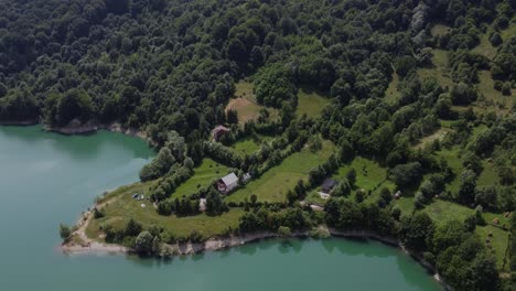 toma de luz diurna en órbita aérea de un pueblo tradicional en un ecosistema saludable de lagos y bosques en paltinu del valle de doftana en rumania