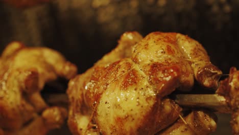 golden brown rotisserie chicken roasting beautifully in oven - close up shot