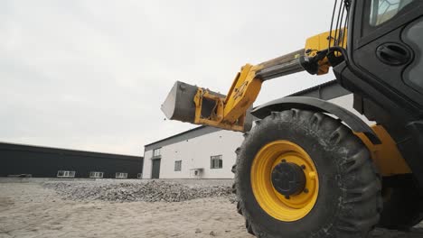 tractor moves rubble to truck. excavator-loader rakes rubble from pile at construction site and loads dump truck. clearing site