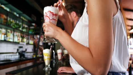 Smiling-friends-having-smoothie-with-straw