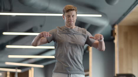 Serious-fitness-man-warming-up-at-gym.-Strongman-doing-exercises-in-sport-club