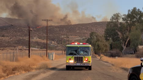 un camión de bomberos se aleja de un incendio forestal