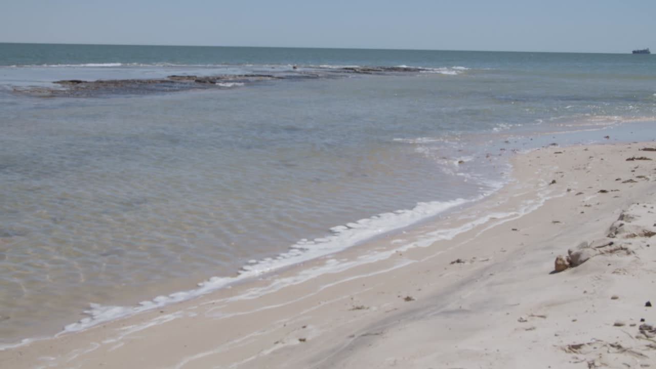 Litoral e um navio solitário distante no oceano