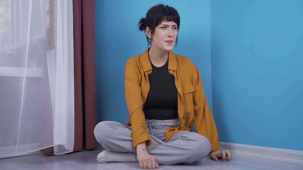 분노로 벽을 때리는 젊은 여성.