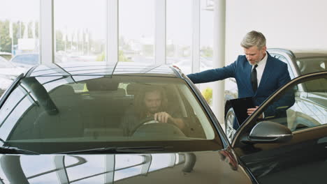 vendedor de coches mostrando un coche a un cliente