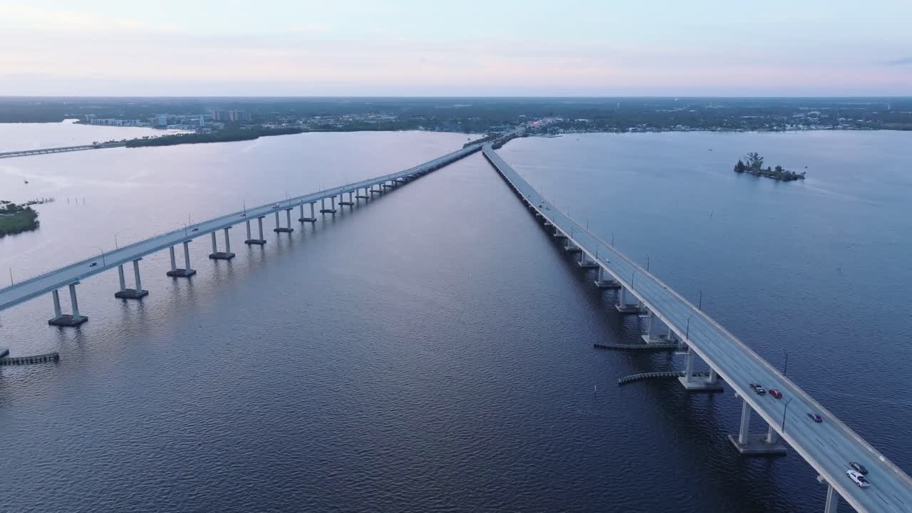 플로리다 주 포트 마이어스 (fort myers) 의 블루 아워 동안 바쁜 다리 사이에 있는 강 위를 향한 공중 비행 - 드론 촬영을 확립하는 것