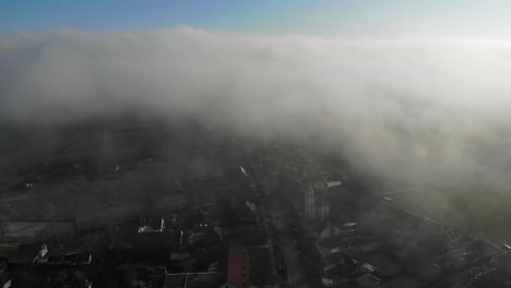 high altitude descending flight through clouds, church apoears on ground