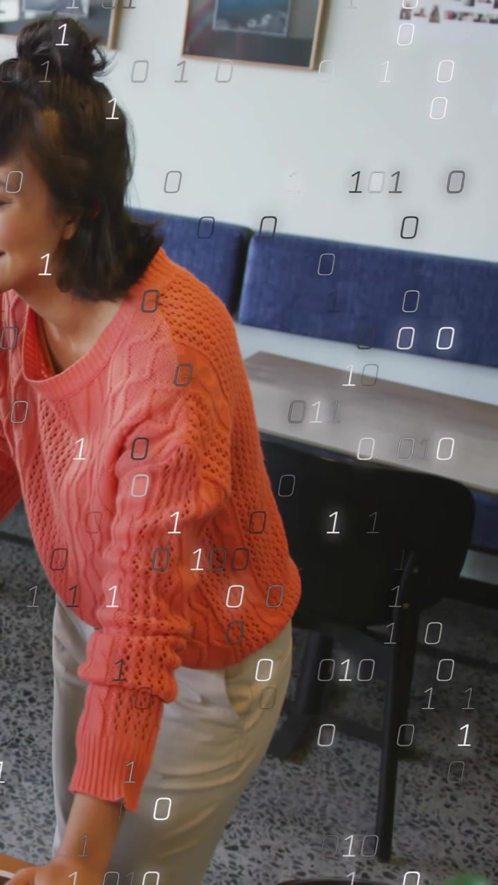 Vertical video: Woman touching desk, causing binary overlay growing and showing tech data