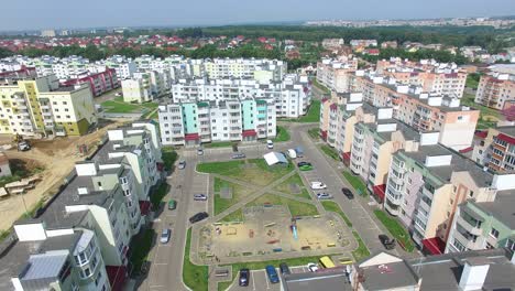 flying over the new built high-rise buildings and many roads for cars in the residential complex in summer. new area in the city with modern buildings in a sunny day. aerial view