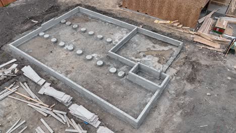 orbiting aerial shot of a fresh construction site with a concrete foundation