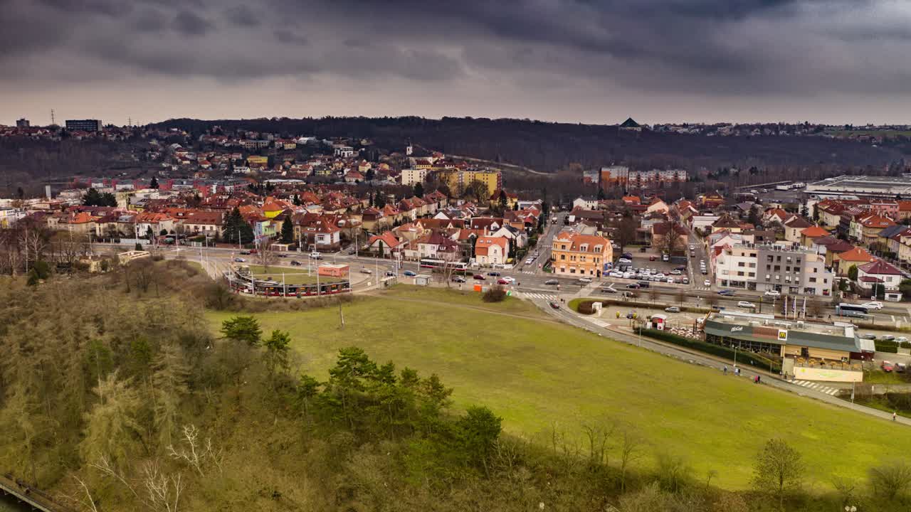 Aerial view of the tram stop near the Divoka Sarka park and Liboc residential district in Prague. Usual traffic on the Evropska avenue, cars, busses and trams. People walking on the sidewalks.