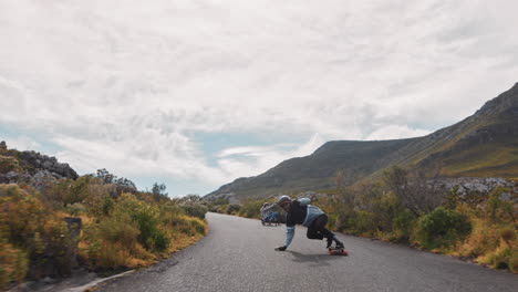 Junge-Freunde-Fahren-Gemeinsam-Longboard-Und-Fahren-Schnell-Auf-Einer-Wunderschönen-Landstraße,-Genießen-Extremsport,-Fahren-Bergab-Und-Machen-Tricks-In-Zeitlupe