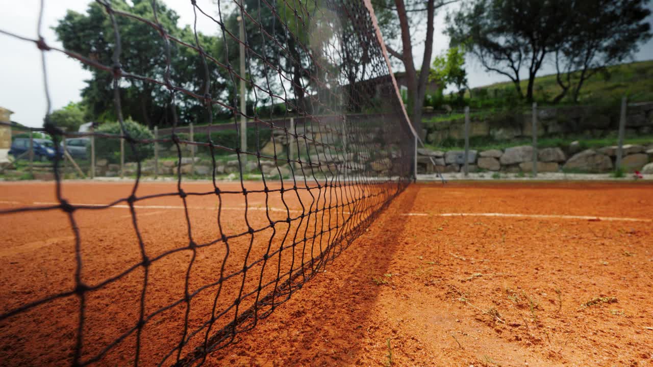 disparo lento de establecimiento de una red de tenis con pistas hechas en la cancha de arcilla