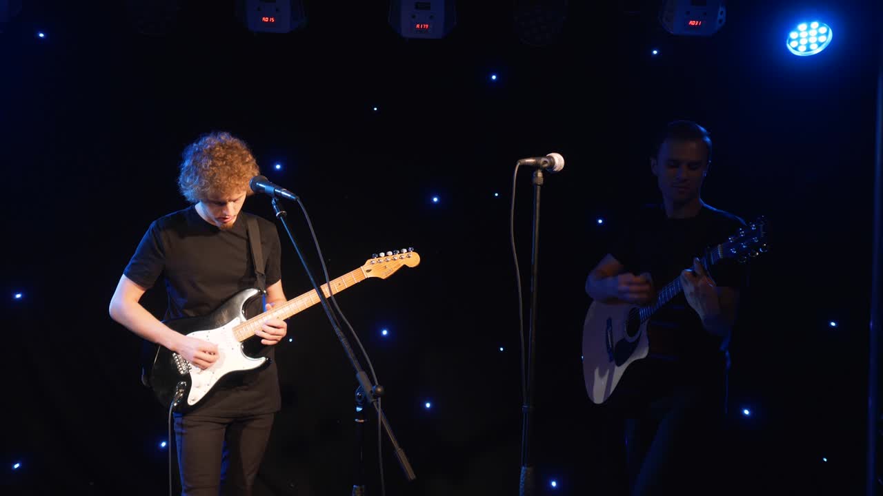 콘서트 록 밴드, 두 개의 전기 기타와 함께 무대에서 공연하는 가수, 뮤직비디오 크, 헤비 메탈 또는 록 그룹, 느린 동작 악기 연주 두 사람의 밴드