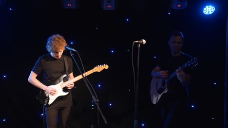 concert rock band performing on stage with two electric guitars singers. music video punk, heavy metal or rock group. slow motion instrument playing band of two men