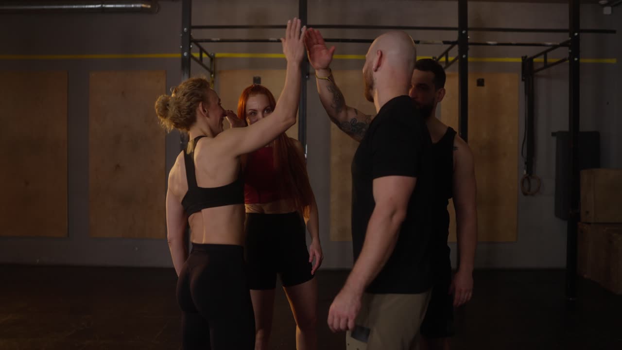 Group of athletes high fiving in a gym after workout