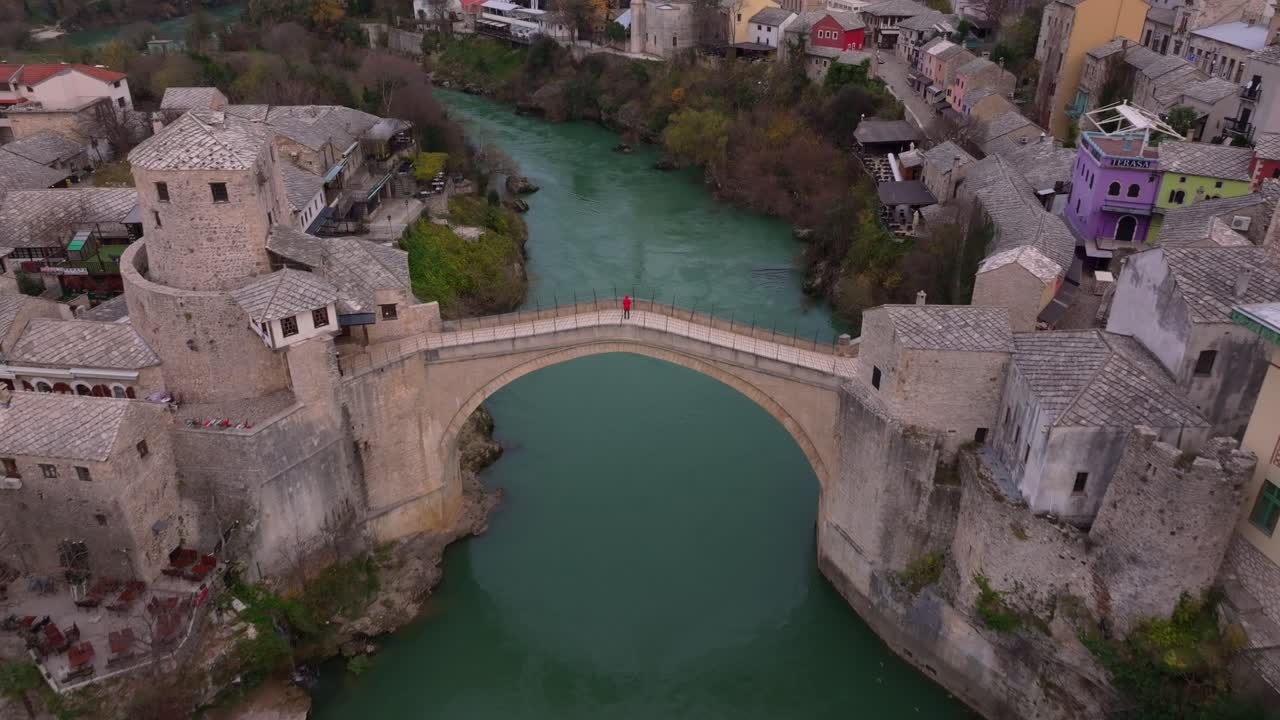 Toma de dron de Stari Most arqueándose sobre el río Neretva al amanecer dorado