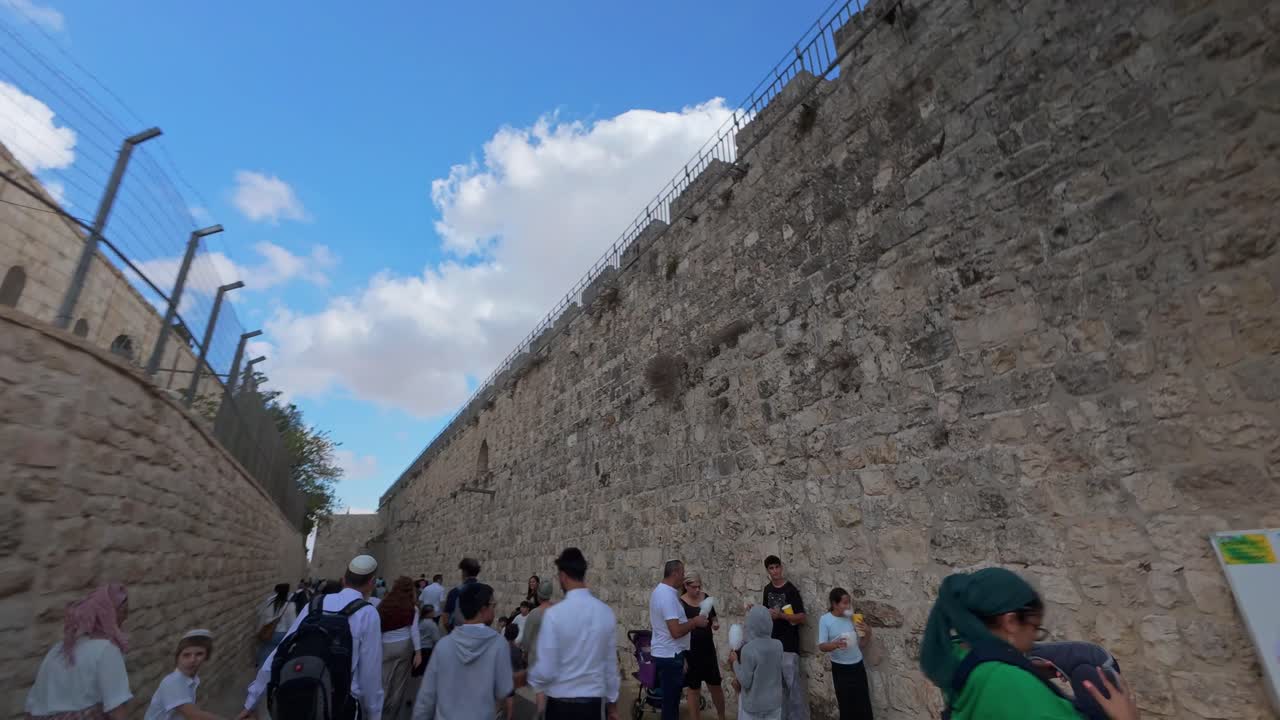 Hyperlapse journey with a large crowd along the massive ancient stone walls of Old City Jerusalem