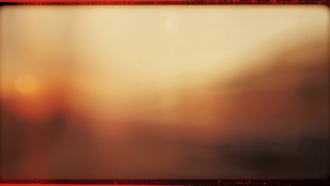Lingering defocused warm-toned gradient filling abstract space, framed by red film border