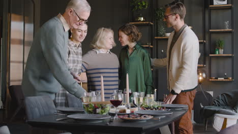 familia feliz en una sala de estar moderna preparando la mesa de comedor juntos 1