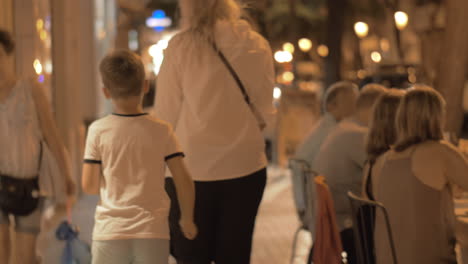 woman with two kids walking in evening city