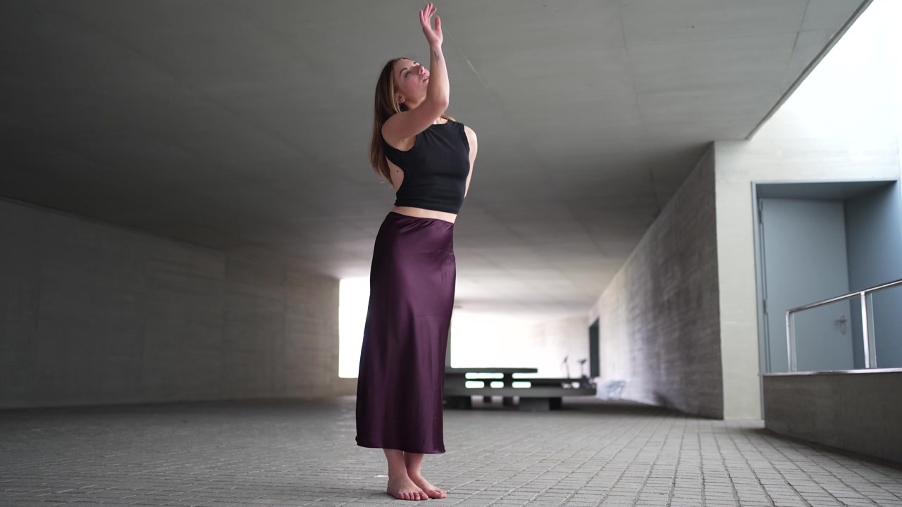 Un'elegante ballerina che esprime con grazia il movimento nella sfera dell'architettura moderna