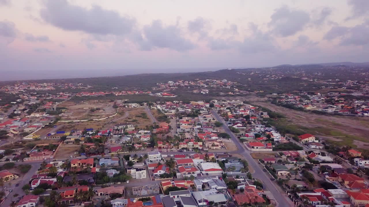 casas en aruba iluminadas por una hermosa puesta de sol rosa y naranja
