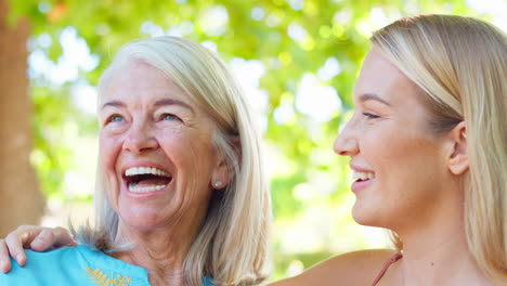 multi-generation family with senior mother and adult daughter laughing in garden together