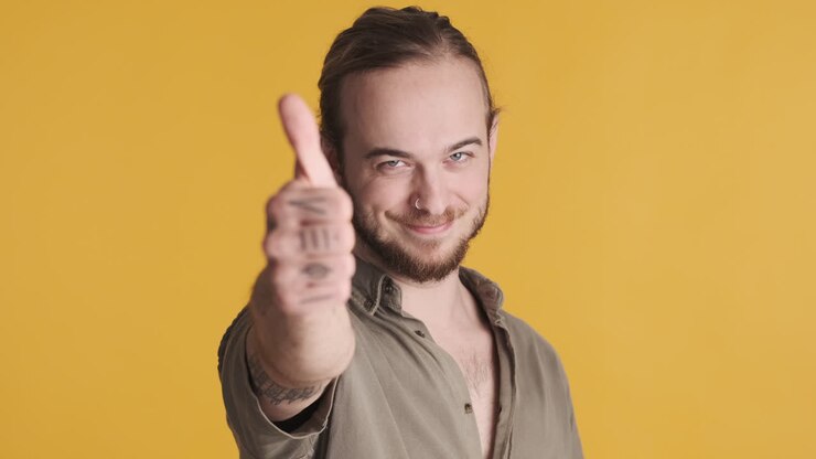 Caucasian young man showing thumb up to the camera.