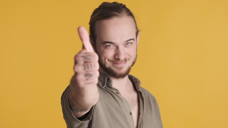 caucasian young man showing thumb up to the camera.