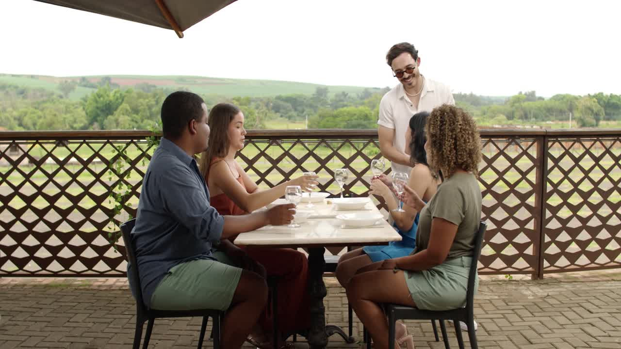 Friends Enjoying Wine and Outdoor Dining at a Scenic Restaurant