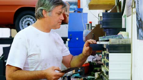 male mechanic checking spare parts while using digital tablet 4k