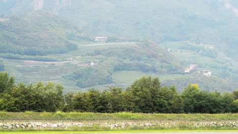 Toma-De-Teleobjetivo-Del-Paisaje-De-La-Pista-De-Aterrizaje-De-Trento-Con-Fondo-Verde-Del-Valle-De-La-Montaña