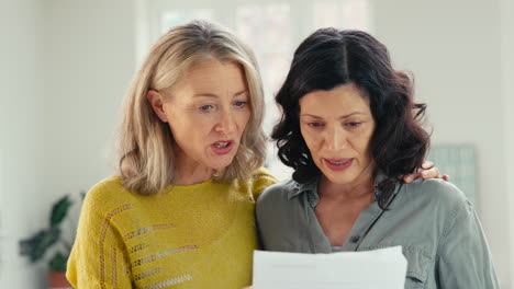 Same-Sex-Mature-Female-Couple-At-Home-Checking-Domestic-Bills-Worried-About-Personal-Finances