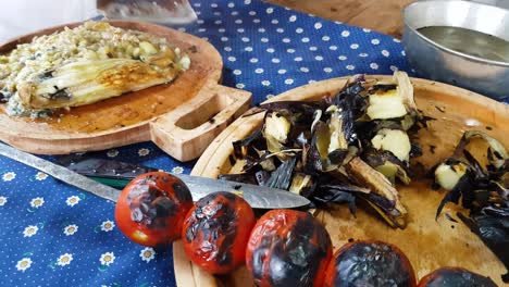 Chopping-axe-knife-for-prepare-food-grilled-aubergine-barbecue-eggplant-tomato-kebab-garlic-recipe-local-traditional-cuisine-mixed-vegetable-cooked-roasted-blue-table-cloth-white-flower-in-Iran-Rasht