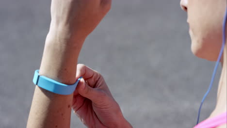 Athletische-Frau,-Die-Vor-Ihrem-Lauf-Einen-Fitness-Tracker-Anzieht