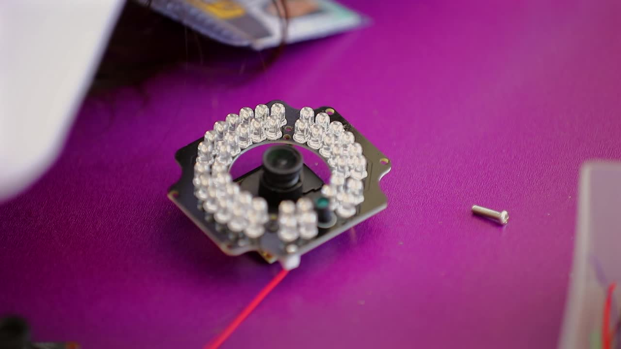 инженер надевает объектив камеры и затягивает винтами