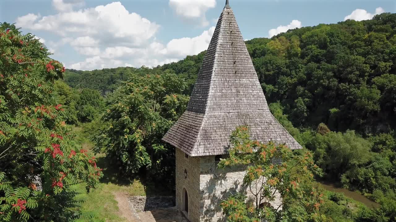Aerial view of Kushnirska Tower surrounded with greenery at Kamianets Podilski,Ukraine.Tilt up and zoom out.