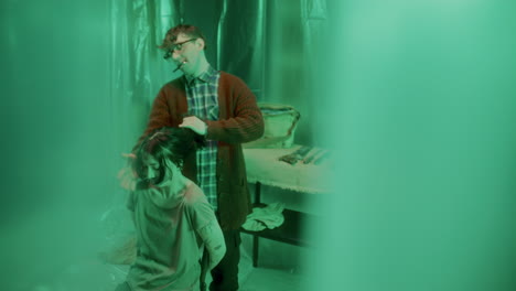 sadistic serial killer threatening shivering girl with knife in dim cellar