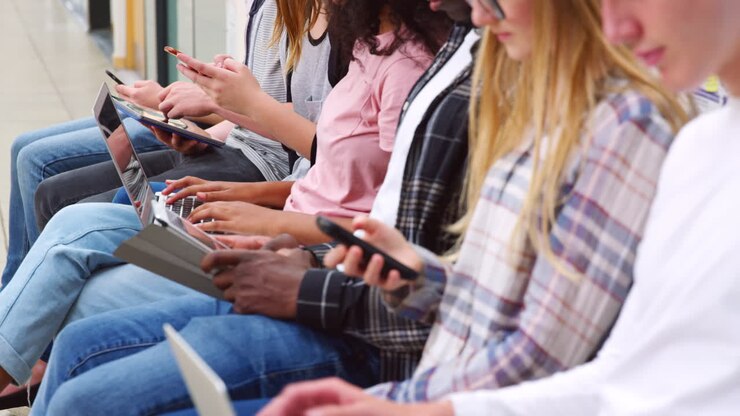 Close Up Of Seated College Students Using Digital Technology
