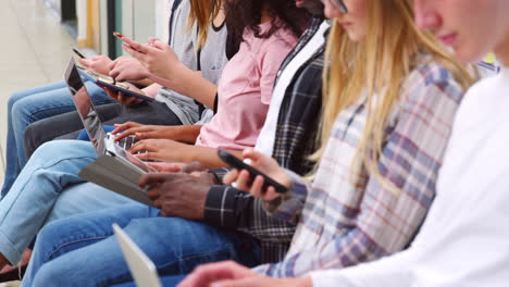 close up of seated college students using digital technology