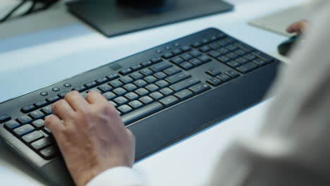 un primer plano de un experto escribiendo en el teclado en la sala del servidor, codificando en la computadora.