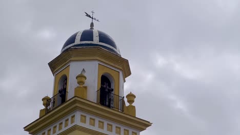 the church bell tower in spain rises majestically against the backdrop of a moody and cloudy sky