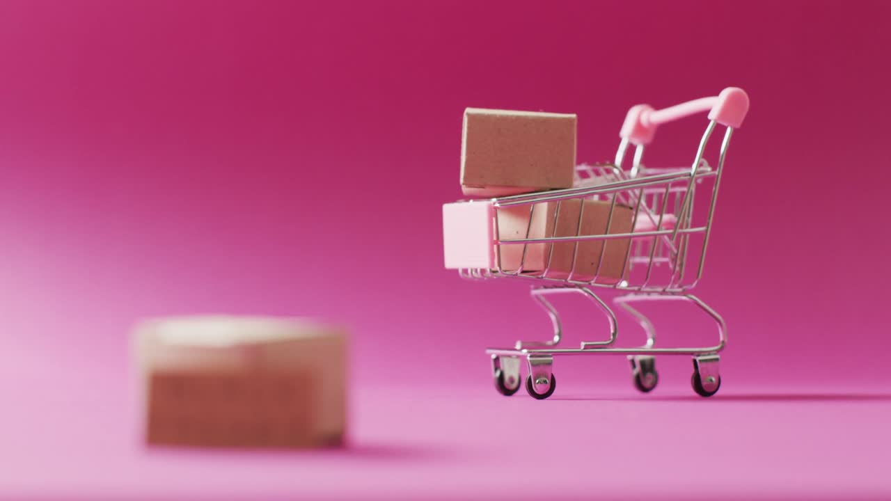 video del texto del viernes negro en cartón y cajas en el carrito de compras sobre fondo rosa