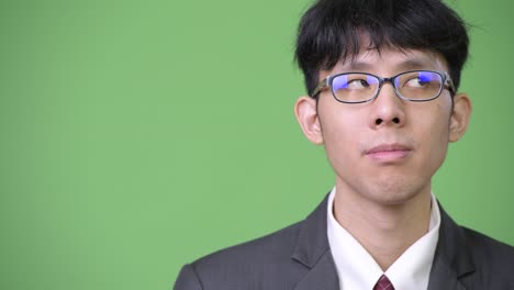 young asian businessman against green background