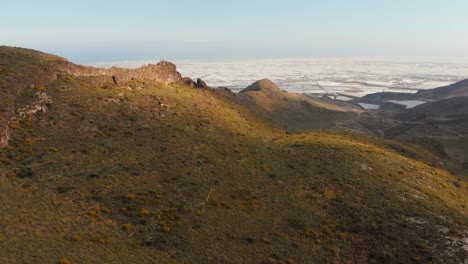 Las-Montañas-Cerca-De-Almería-En-El-Sur-De-España-Con-Al-Fondo-Los-Invernaderos,-Tiro-Aéreo