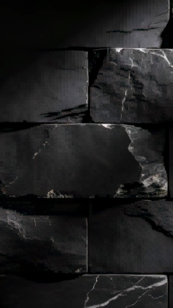 Vertikales Video: Eine gleitende Kamera enthüllt eine dunkle Schieferwand im Innenbereich, die blasse Adern und Fugen zeigt.