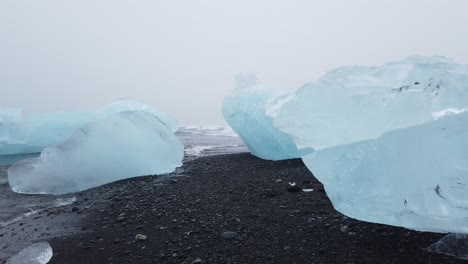 close up shot of sea waves crashing the ice rocks kept in the seashore