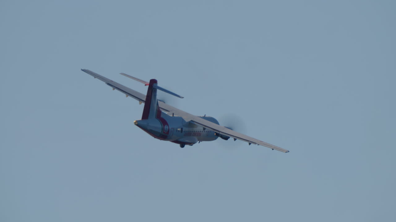 Aereo a elica della Guardia Costiera in volo e in virata nel cielo azzurro